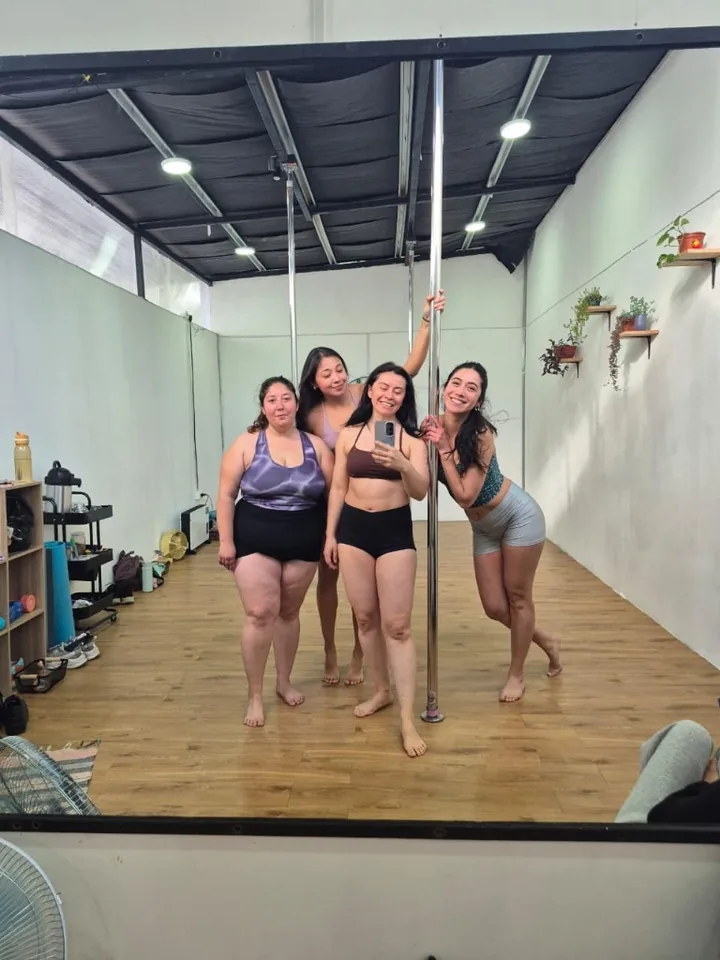 Tres alumnas con polerones del estudio posando entre dos barras