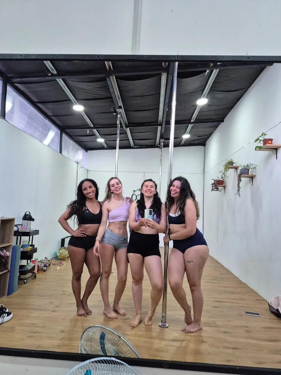Alumnas posando en el espejo del estudio, con el ventilador y las plantas