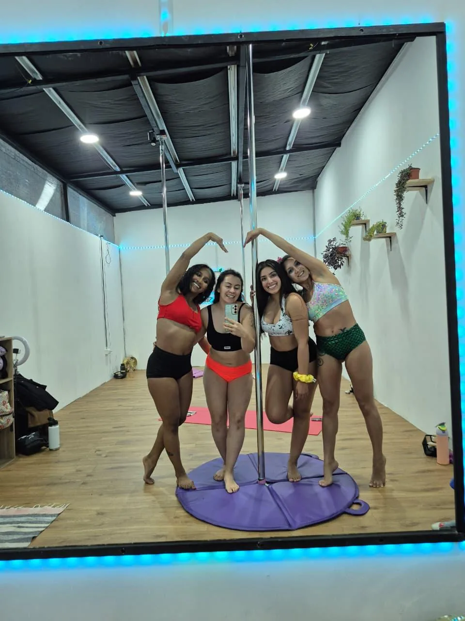 Cuatro alumnas formando un corazón con los brazos sobre la barra